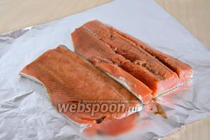 Отрежьте кусок фольгу, размером примерно 80х30 см. Кижуча посолите, поперчите, смажьте «жидким дымом» и вустерским соусом. Выложите куски рыба на фольгу.