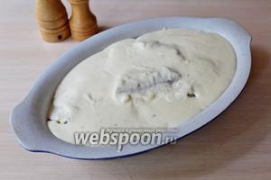 Залить рыбу с картофелем соусом «Бешамель» и выпекать в заранее разогретой до 190°С духовке 30 минут.