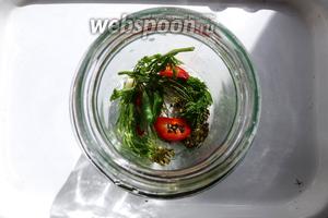 В чистую банку кладём лист смородины, укроп, морковную ботву, чеснок, по кусочку чили и сладкого перца.