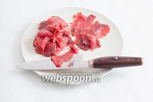 Если у вас идеально острые ножи и вы способны нарезать сырое мясо на толщину носовых платков без дополнительных хитростей, то респект вам и уважуха, повторите подвиг древних японцев и сделайте это! Для владельцев морозилок, однако, будет лучше уложить кусок говядины на заморозку, пока она не затвердеет. Но затвердение должно произойти не до твердокаменного состояния, а просто для того, чтобы мясо стало проще резать. Удобнее всего это делать дисковой электрической машинкой для нарезки, но можно и хорошим острым ножом с широким лезвием. Толщина кусков — «чем тоньше, тем лучше».