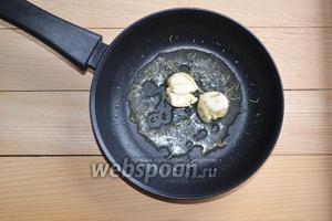На разогретую сковороду выкладываем кусочек масла. Через 1 минуту добавляем раздавленный чеснок и розмарин.