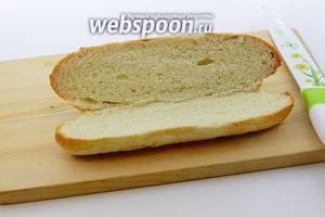 Булочку для хот-дога немного подогрейте в микроволновке. Аккуратно разрежьте пополам, не дорезая до конца. Булочка должна открываться, как сундучок.