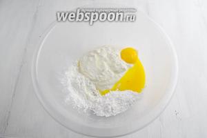 Мягкий творог (если нужно, протереть через сито), сахарную пудру, кукурузный крахмал, 2 желтка, ванильную эссенцию поместить в глубокую миску.