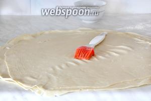 На нижнюю лепёшку теста положить второй, тонко раскатанный пласт, снова смазать жиром и повторить то же самое с третьим пластом раскатанного теста. Получается 3 слоя смазанного теста, один на одном. Вообще, можно сворачивать и каждый слой отдельно, но так, мне кажется, гораздо богаче получается результат.