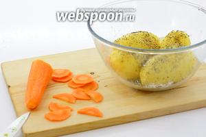 Морковь нарежьте тонкими полукольцами. К картошке насыпьте розмарин и тимьян, соль, перец молотый. Перемешайте.
