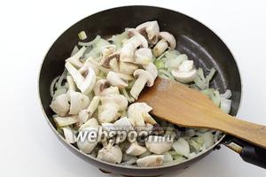 Лук нарежьте произвольными кусочками, можно полукольцами. Шампиньоны промойте. По желанию, удалите кожицу. Разрежьте на 4 части вместе с ножками. На подсолнечном масле обжарьте лук до мягкости. Добавьте грибы. Перемешайте и обжарьте до готовности.