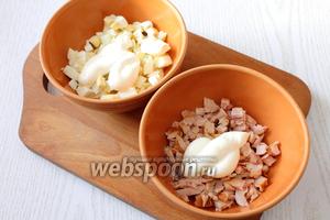 Также нарезаем кубиками очищенные яйца и мясо курицы (очищаем от костей и кожицы), заправляем по 1 ст. л. майонеза.