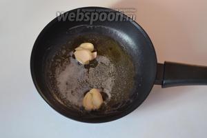 На разогретую сковороду выкладываем сливочное масло. Когда оно растает, добавляем очищенные и немного раздавленные прессом зубчики чеснока. Обжариваем чеснок с 2 сторон по 1 минуте и достаём его со сковороды.