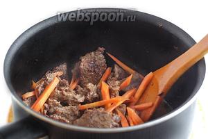 Обжарить мясо на растительном масле до изменения цвета и легкого румянца. Затем слегка посолить, добавить морковь. Жарить пару минут.