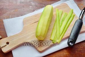 Первым делом очищаем кабачок от кожуры и с помощью овощечистки нарезаем длинными пластинами.
