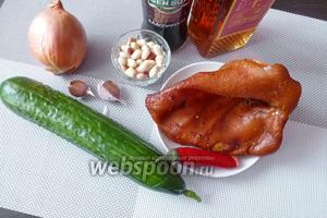 Для приготовления салата понадобится копчёное свиное ухо, салатный огурец, луковица. Для соуса — кунжутное масло, соевый соус, чеснок, кусочек чили. Для посыпки салата — подсушенный арахис и крупная морская соль.