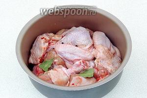 Выложить куски курицы в чашу мультиварки, посыпая солью, крупно разломанным лавровым листом и горошинами перца. Воды и масла в чашу не добавлять!
