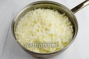 Нашинкованную капусту сложить в глубокую посуду или сковороду. Ошпарить кипятком. Через 2-3 минуты капусту отбросить на дуршлаг, чтобы вода стекла.
