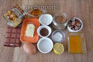 Для приготовления необходимы яйца, сахар, масло сливочное, шоколад, мёд, какао, мука пшеничная, корица, разрыхлитель, ванилин, лимон, коньяк, варёная сгущёнка, орехи фундук.