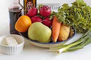 Для приготовления салата возьмём яркую морковь, лучше 2 цветов, кисло-сладкое яблоко, лимон (на фото половинка оранжевого лимона, у нас такие местные), весенний редис, салатные листья, зелёный лук и перо зелёного чеснока, свежую кинзу, гранатовый сироп, оливковое масло, Фетаксу.