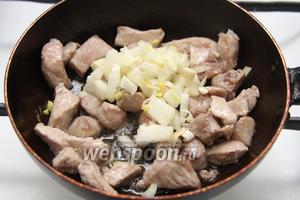 Когда мясо побелеет, добавить лук.