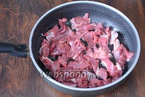 300 г мяса нарезаем небольшими полосками и выкладываем на раскалённую сковороду с подсолнечным маслом (2 ст. л.).