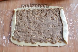На прямоугольнике раскатать или распределить руками ореховую начинку. Завернуть меньшие края на 1-2 сантиметра.