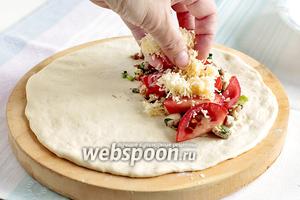 Из 1 порции теста сделать лепёшку. На 1 край выложить 1/3 куриного мяса, 1/3 долек помидор, посыпать всё 1/3 частью сыра.