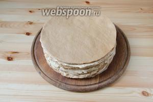 Снова выкладываем медовый корж, а затем 2 слоёных. Повторяем так, используя все коржи. При необходимости ровняем бока, срезая лишние выступы ножом.