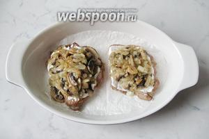 На каждую отбивную выложить грибы с луком. Поставить форму с мясом в духовку, разогретую до 190-200°С, на 15-20 минут.