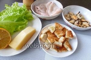 Для салата Цезарь с морепродуктами возьмём свежемороженые кальмары, подкопченные мидии, зелёный салат, сыр Пармезан, лимон, чёрный перец и сухарики из багета или булки. Как их готовить, я рассказывала в рецепте «салат Цезарь с рыбой».
