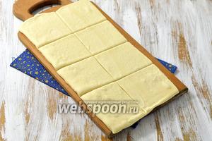 Размороженное тесто раскатать до толщины 2 мм и разрезать на квадраты, которые по размеру подходят к ячейкам вашей бутербродницы.
