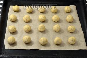 Разделить тесто на небольшие кусочки размером с грецкий орех. Скатать кусочки в шарики и разложить на противне с пергаментной бумагой, соблюдая между ними расстояние.