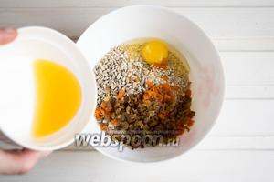 Смешать в посуде овсяные хлопья (120 г), яйцо (1 шт.), изюм и курагу. Засыпать семечки (30 г) и влить апельсиновый сок (35 мл). Тщательно перемешать смесь.
