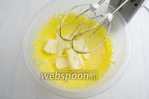 Добавить куски сливочного масла (250 г) комнатной температуры. Продолжить взбивать массу до пышной консистенции.
