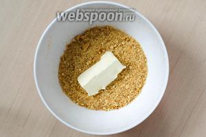 Печенье (100 г) измельчаем в мелкую крошку и смешиваем с размягчённым сливочным маслом (40 г) до однородности.