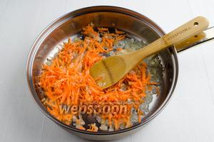 Морковь (1 шт.) очистить. Измельчить крупно на тёрке. Добавить подготовленную морковь к луку. Продолжить жарить до мягкости моркови.