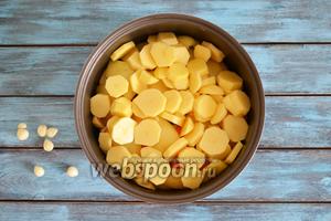 5 картофелин очистить, нарезать кольцами, посолить и выложить сверх перца. Добавить 3 зубчика очищенного чеснока.