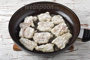 Нарезать филе порционными кусочками, обвалять в муке (4 ст. л.) и выложить кожицей вниз на разогретую сковороду с подсолнечным маслом (4 ст. л.). Из предложенного количества продуктов у меня получилось 2 таких захода обжаривания кусочков хека. Обжарить 2-3 минуты.