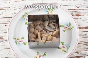 На блюдо выложить квадратную рамку (можно круглую) для формовки салатов. На дно выложить нарезанную кусочками селёдку (200 г).