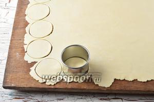Вынуть тесто из холодильника и раскатать толщиной 1,5-2 миллиметра. Вырезать чётное количество кружков диаметром 5-7 сантиметров (по 2 на 1 пирожок).