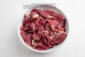 Пока варятся грибы, подготовить куриные сердечки (500 г). Куриные сердечки вымыть. Срезать верхнюю часть сердечка, разрезать его пополам, убрать запекшуюся кровь, ещё раз промыть. Просушить куриные сердечки на салфетке.