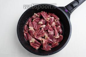 Нагреть сковороду с подсолнечным маслом (2 ст.л.). На сковороду выложить подготовленные куриные сердечки. Тушить их в течение 15 минут.