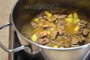 Добавляем порезанный на средние кусочки картофель (3 штуки) и доливаем воду. Она должна слегка покрывать мясо. Воду можно заменить бульоном или сухим красным вином. Теперь закрываем крышкой и на медленном огне тушим до готовности картофеля. Около 20 минут.