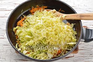 Капусту очень мелко нашинковать (воспользуйтесь для этого специальной тёркой). Соединить капусту (350 г) с солью (0,75 ч. л.) и помять. Отправить подготовленную капусту в сковороду. Перемешать. Готовить 3-4 минуты.
