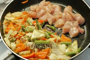 Сдвигаем овощи на одну половину сковороды и на другую кладём мясо курицы. Обжариваем до готовности.