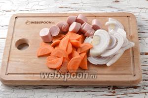 5 сосисок освободить от оболочки и нарезать небольшими кусочками. 1 морковь очистить и нарезать тонкими полукружочками. 1 Лук очистить и нарезать полукольцами.