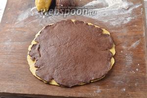 Вынуть тесто из морозильной камеры. Разделить каждый вид теста на 2 равных куска. У нас получится 4 куска теста. Раскатать на слегка подсыпанной мукой доске по отдельности белый и шоколадный куски теста в круглые пласты толщиной 0,4 см. Выложить шоколадный пласт теста на белый и слегка пройтись сверху скалкой, чтобы пласты соединились между собой.