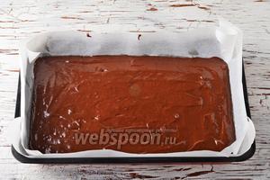 Форму (размером 22х32 сантиметра) выложить пергаментом. Вылить тесто в форму и разровнять. Выпекать в предварительно разогретой до 180°С духовке до готовности коржа (до сухой лучинки), приблизительно 35-40 минут. Вынуть корж, остудить, снять пергамент.