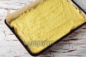 Форму (размером 22x35 сантиметров) выложить пергаментом. Если вы сомневаетесь в качестве своего пергамента, смажьте его дополнительно 1 столовой ложкой подсолнечного или сливочного масла. Выложить тесто в форму и разровнять.