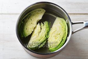 В кастрюле довести небольшое количество воды до кипения. Порциями по 3-4 штуки опускать капусту в воду. Варить на небольшом огне 3-4 минуты. Вынуть и сложить в дуршлаг. Дать стечь воде.