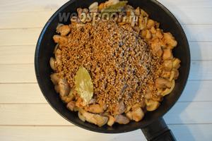 Продолжая обжаривать, добавить лук, смесь специй для мяса (1 ст. л.) и соль по вкусу, и 2 лавровых листа. Перемешать. Выложить подготовленную гречневую крупу 2 стакана.