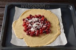 У вишни (500 г) удалить косточки и перемешать ягоды с картофельным крахмалом 2 ст. л. Перенести пласт, вместе с нижним листом пергамента, на противень. В центре выложить подготовленные вишни (разделить всю вишню на 2 части, так как у нас получатся 2 галеты).