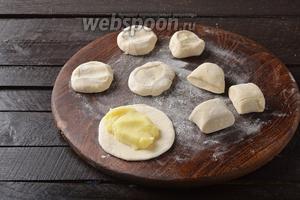 Разделить тесто на небольшие кусочки. Каждый кусочек раскатать в лепёшку, толщиной приблизительно 3 миллиметра. На середину раскатанной лепёшки выложить 1 столовую ложку начинки.