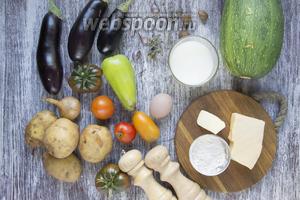 Подготовить продукты: баклажаны, кабачки, картошку, лук, сливочное масло, молоко, муку, молотый мускатный орех, орегано, перец, помидоры, соль, сыр, чеснок и яйца.